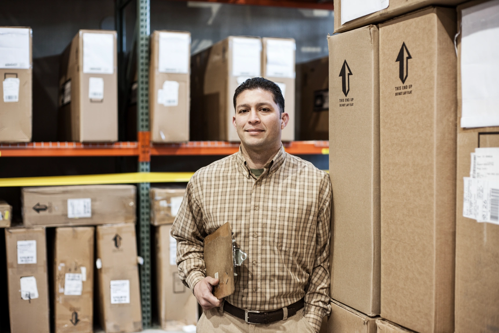 warehouse-worker-among-racks-of-boxed-products-in